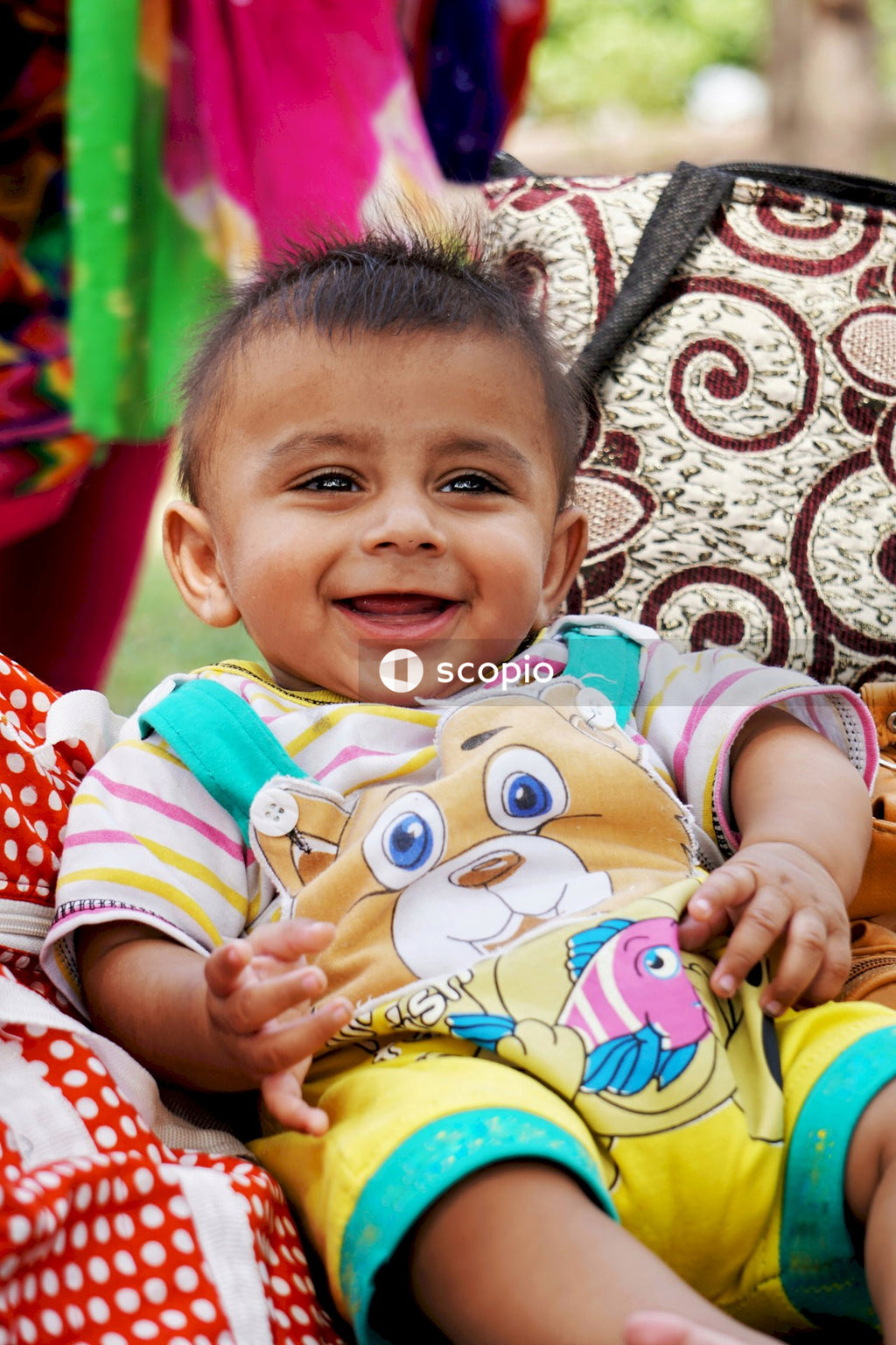 South Asian baby smiling wearing colorful clothes