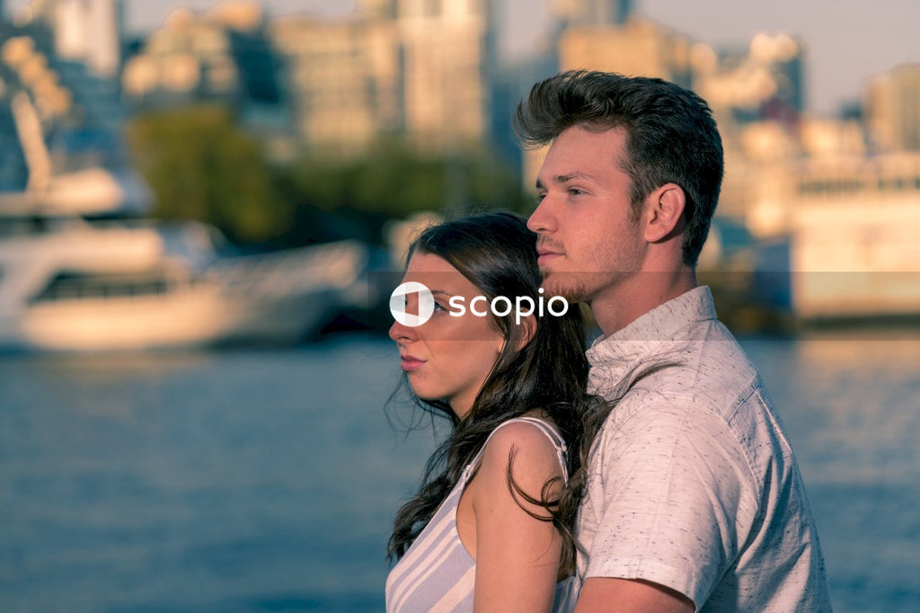 Man in gray dress shirt kissing woman in white sleeveless top