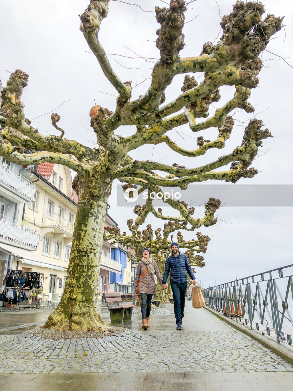 Couple walking on sidewalk near white building