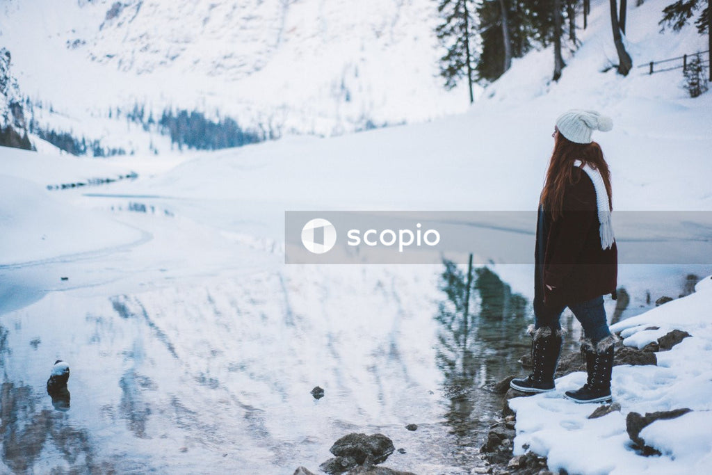 Woman wearing winter clothes standing on snow covered ground