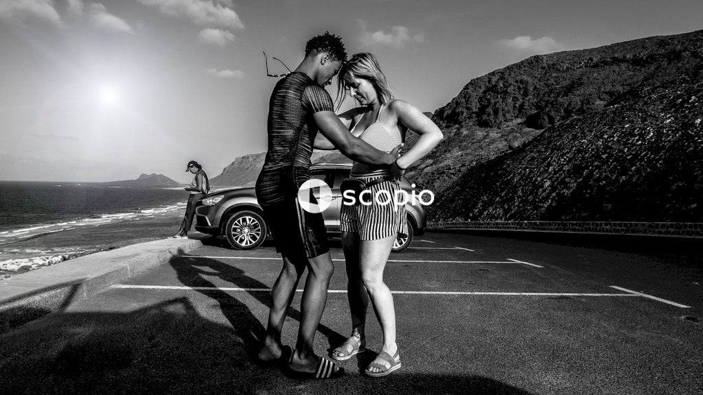 Grayscale photo of woman in stripe dress hugging woman in stripe dress