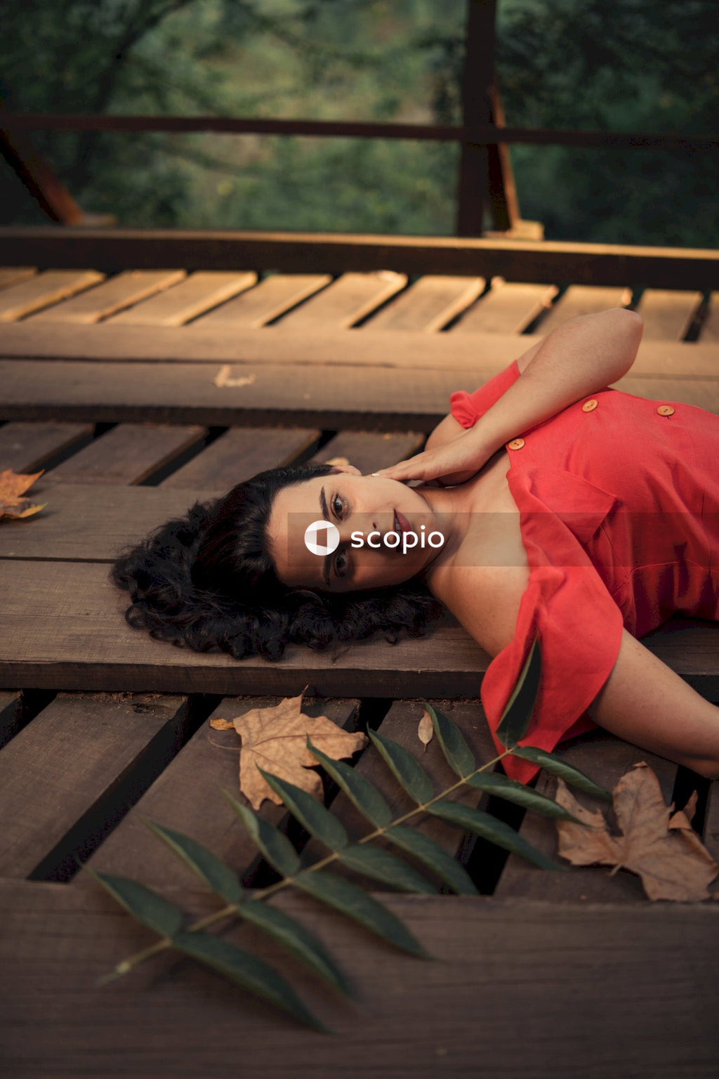 Woman in red shirt laying on brown wooden dock