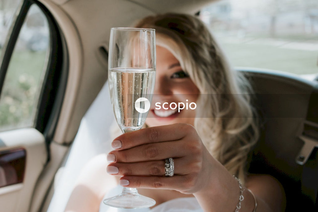 Woman holding champagne glass in a car