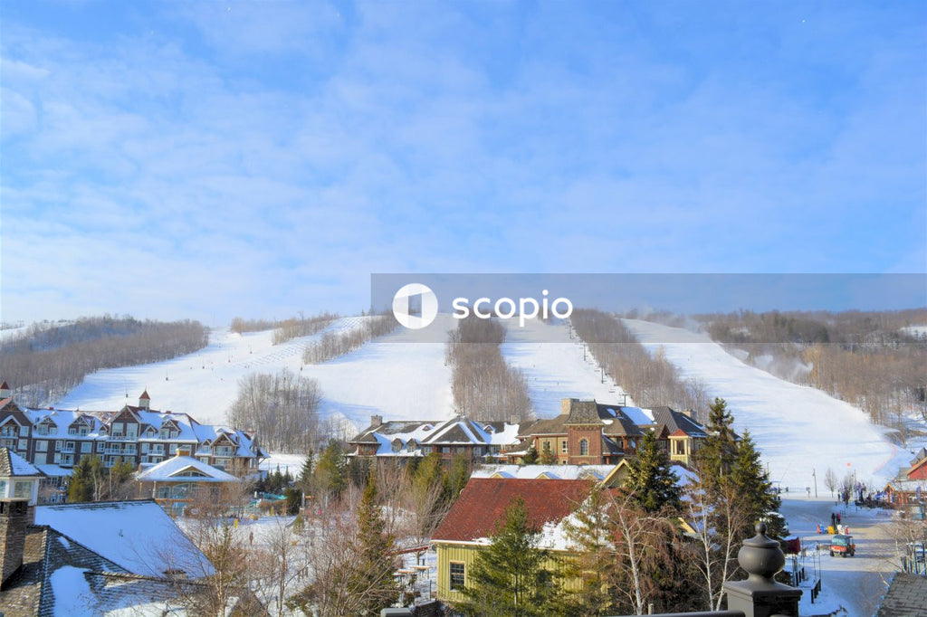 Brown and white houses on snow covered ground under blue sky