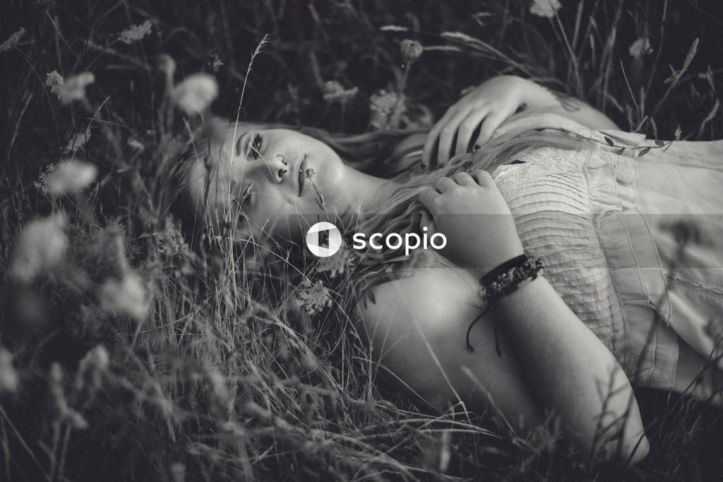 Grayscale photo of woman lying on grass