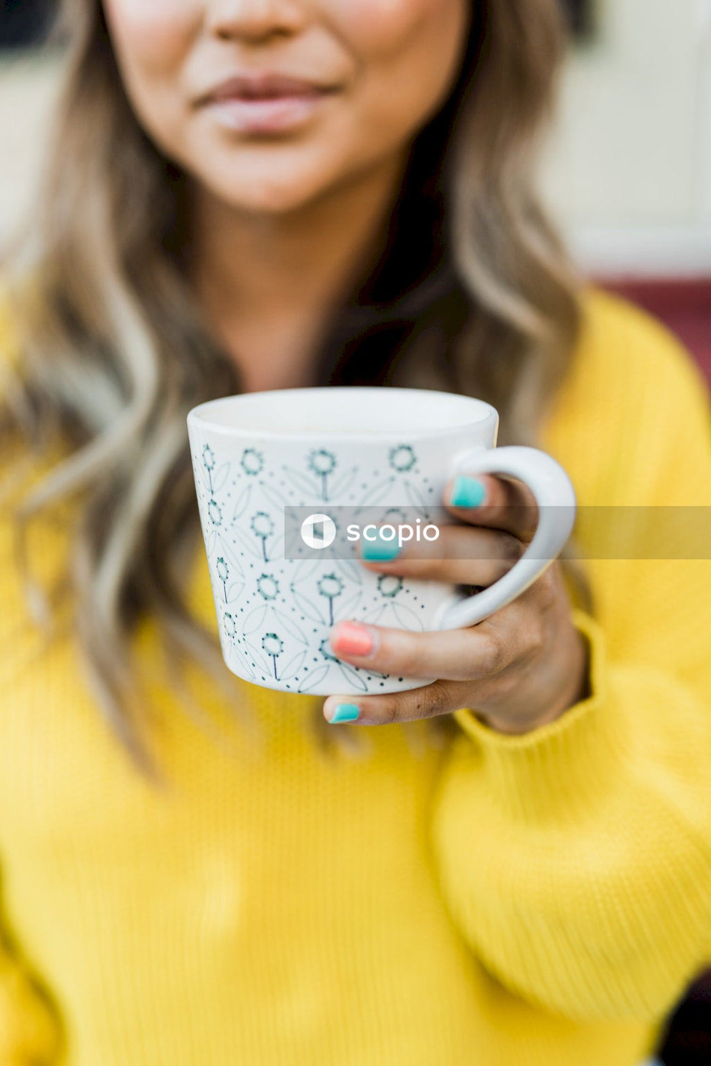 Woman in yellow sweater holding mug
