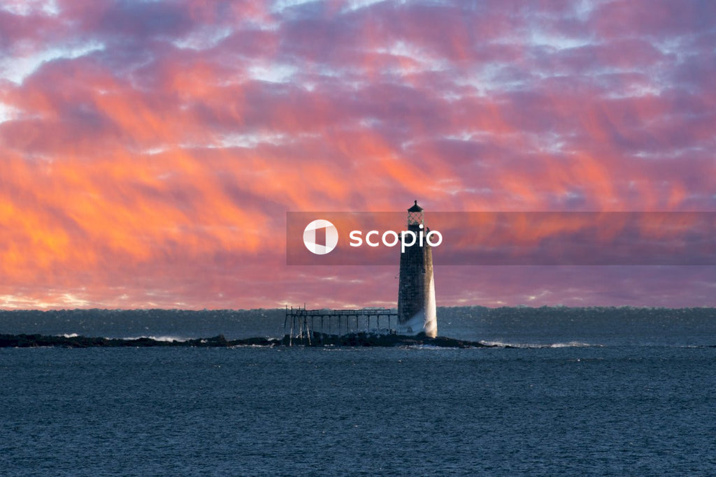 White lighthouse on sea shore during sunset