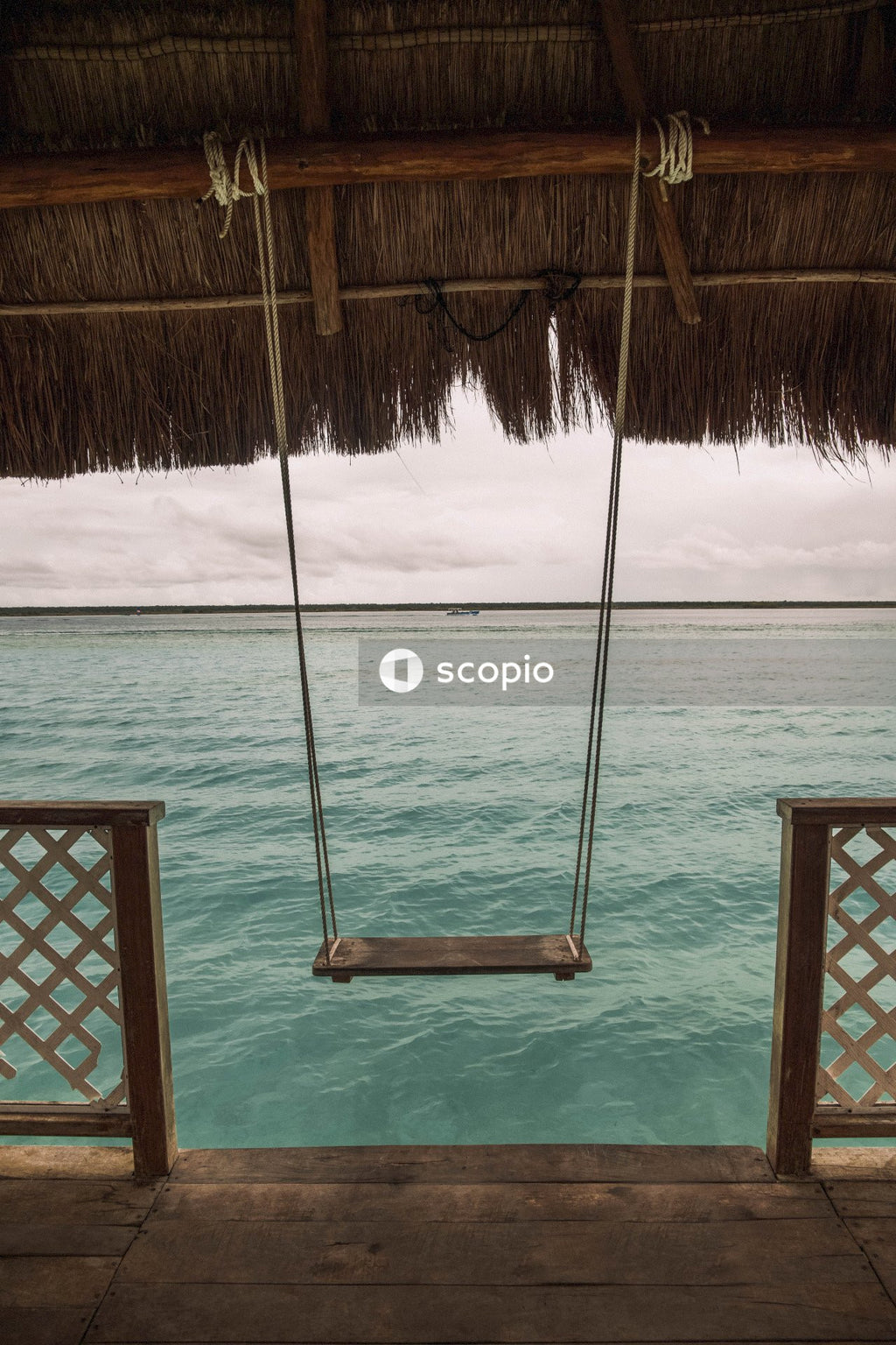 Brown wooden swing on body of water