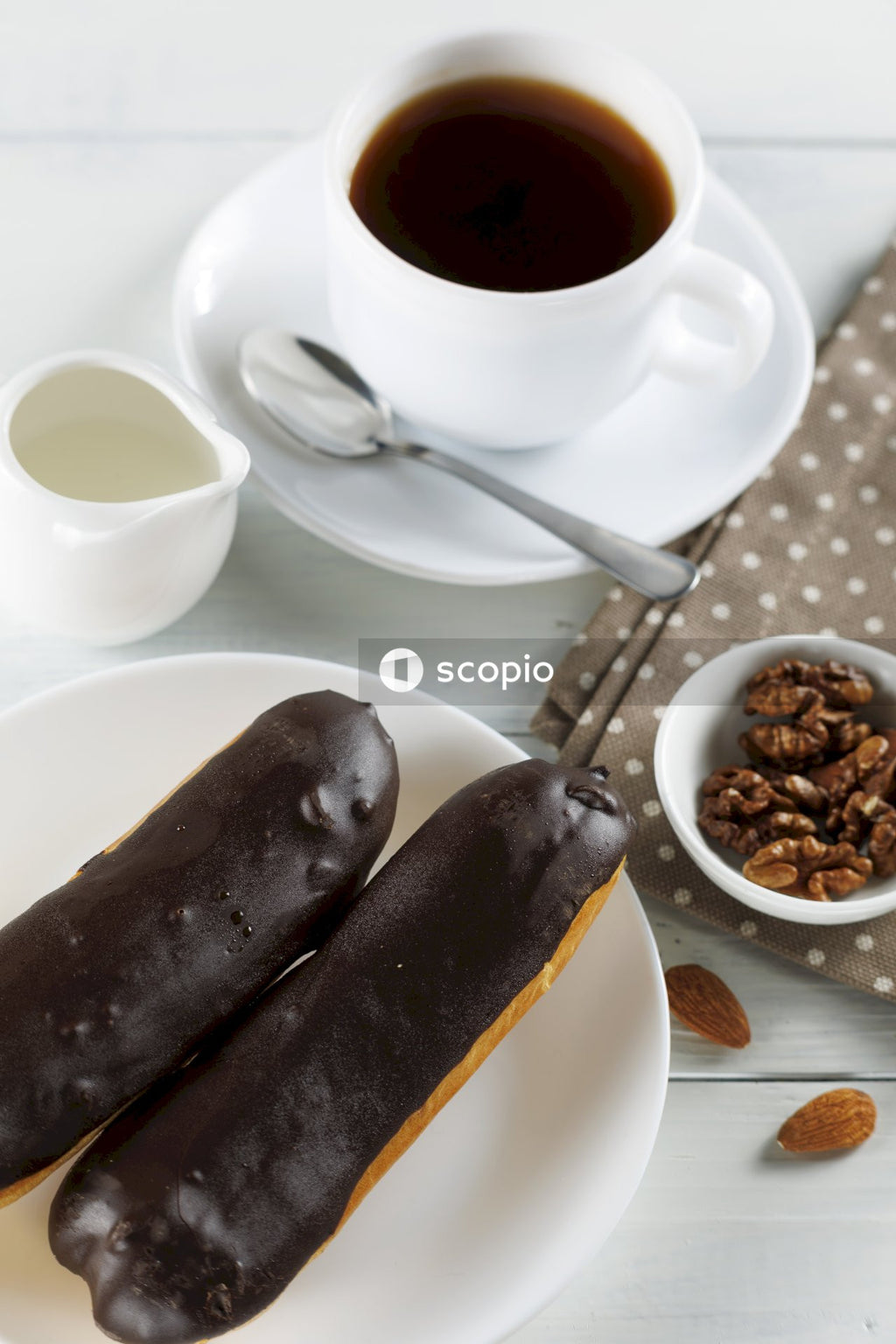 Chocolate cake on white ceramic plate beside white ceramic mug with coffee