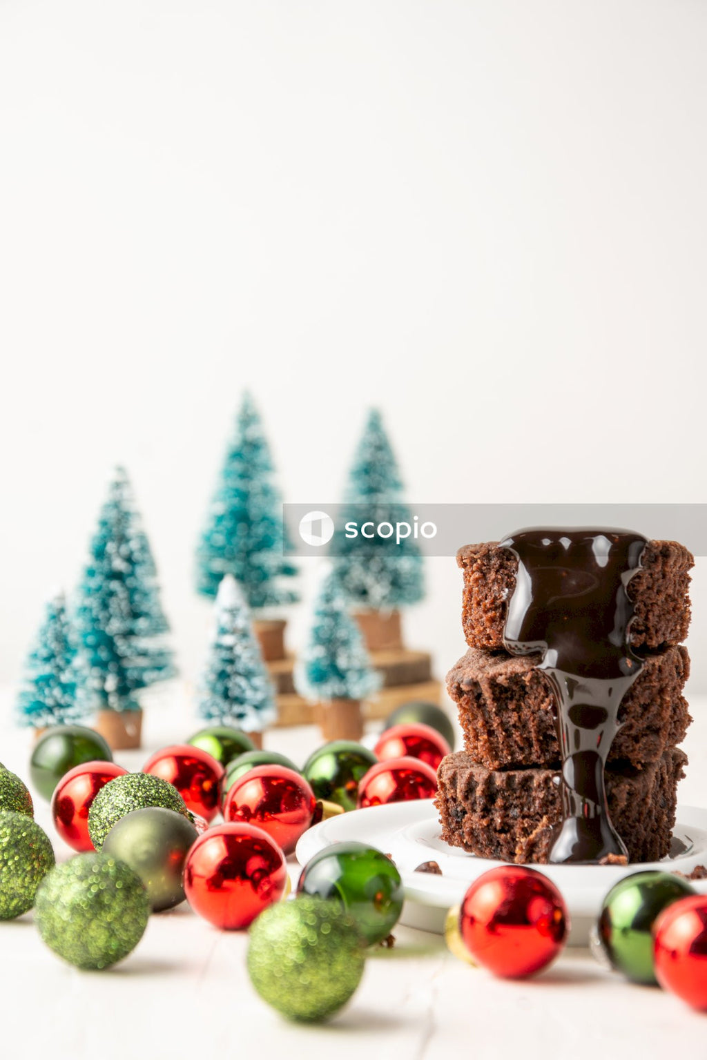Chocolate cake with red and green baubles on white ceramic plate