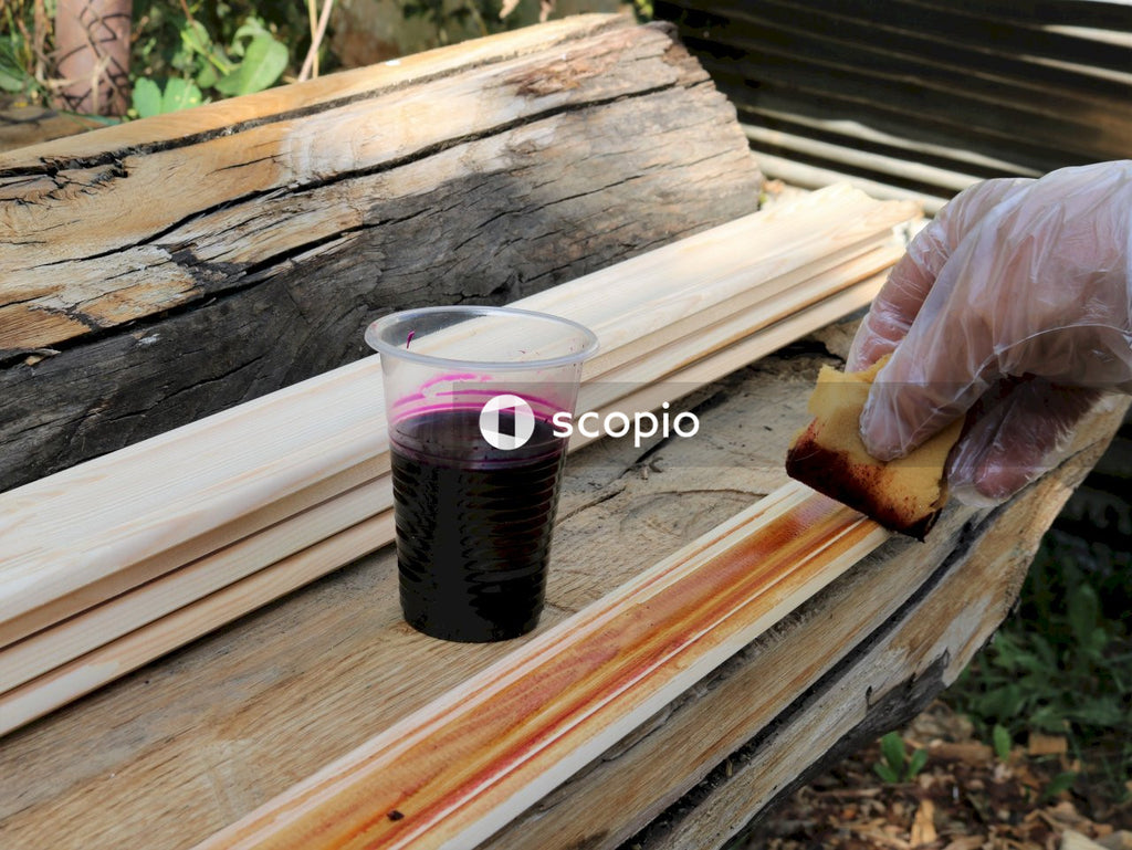 Clear drinking glass with black liquid on brown wooden table