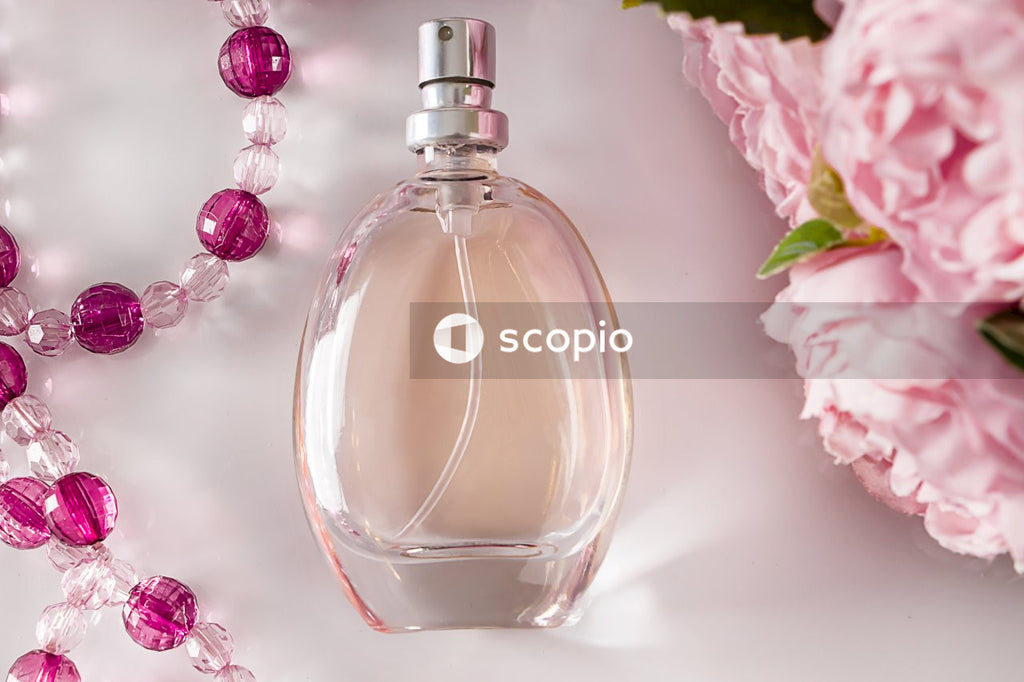 Clear glass perfume bottle on white and pink floral textile