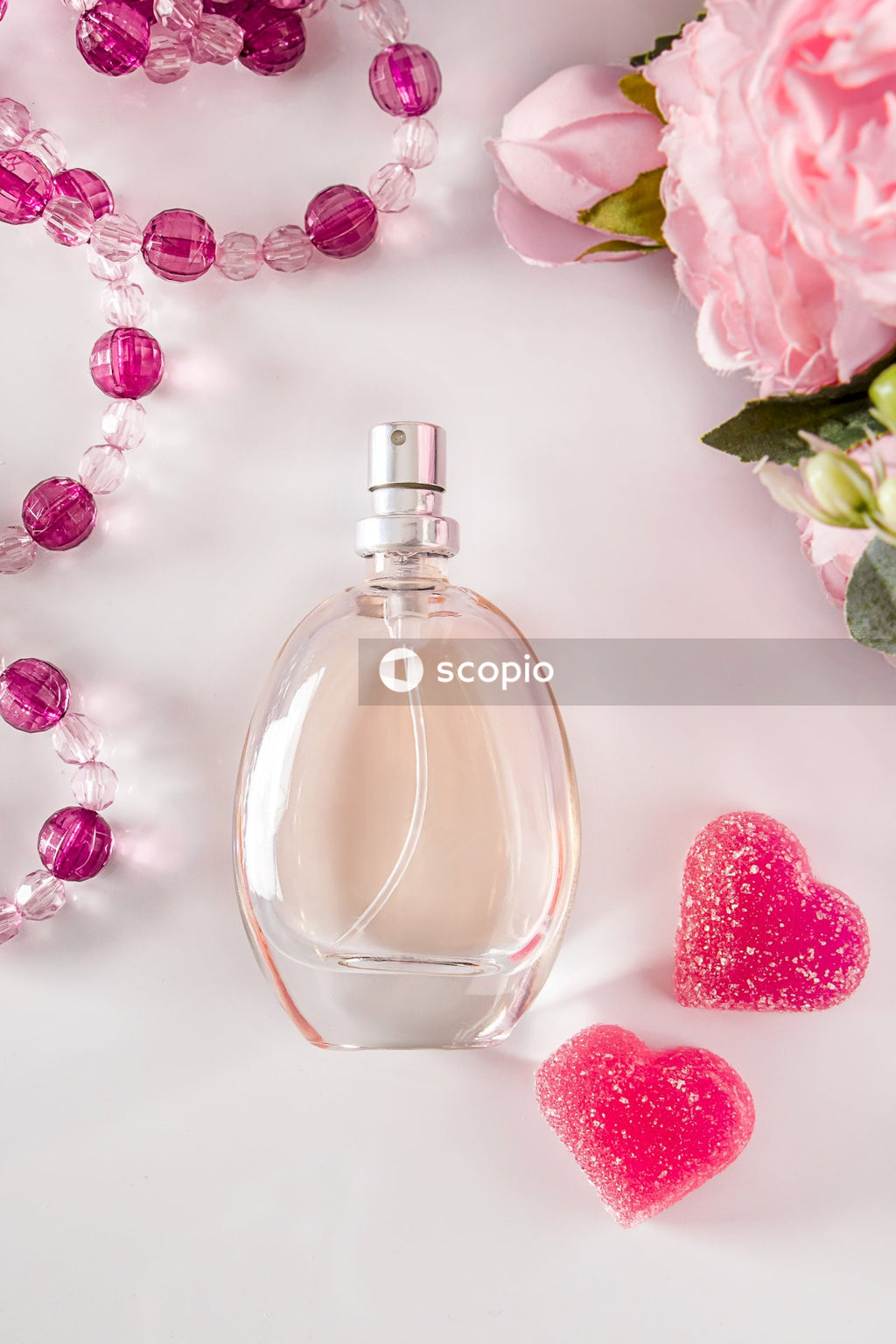 Clear glass perfume bottle with red heart shaped candies