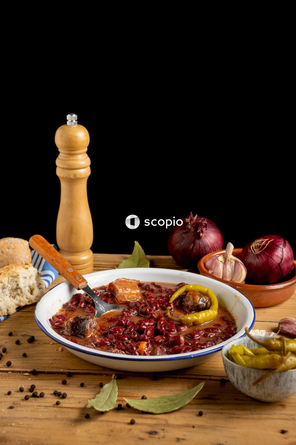 Cooked food on white ceramic plate beside brown wooden pepper mill