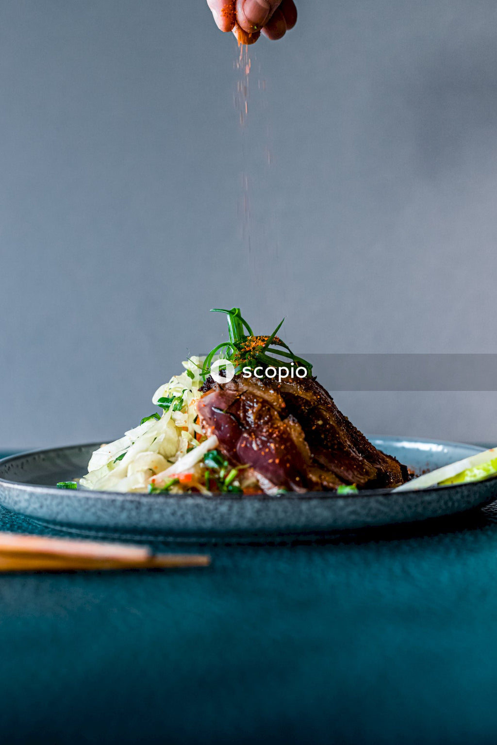 Cooked meat with green vegetable on blue ceramic plate