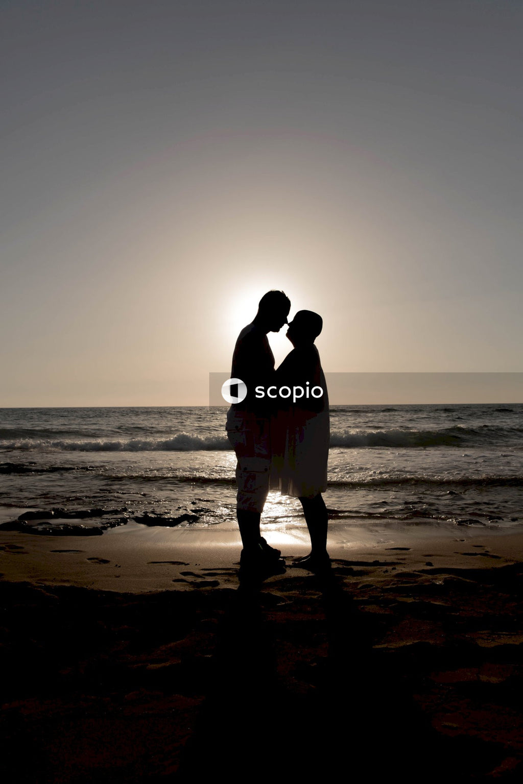 Couple kissing on beach during sunset