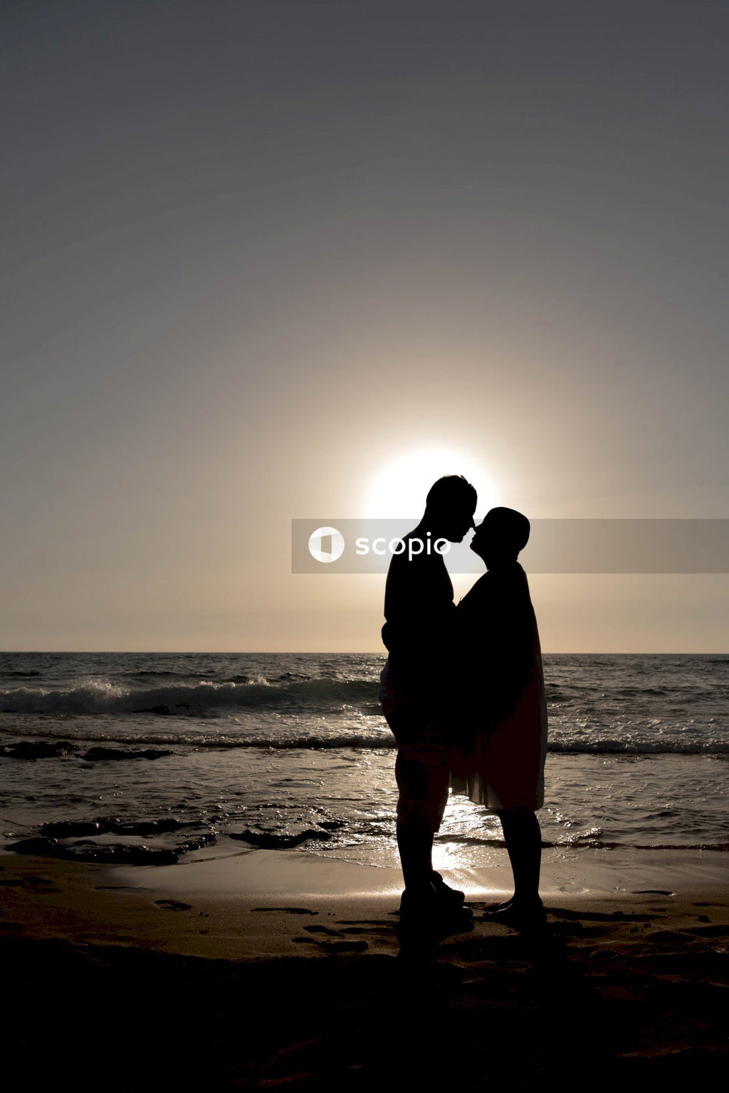 Couple kissing on beach during sunset
