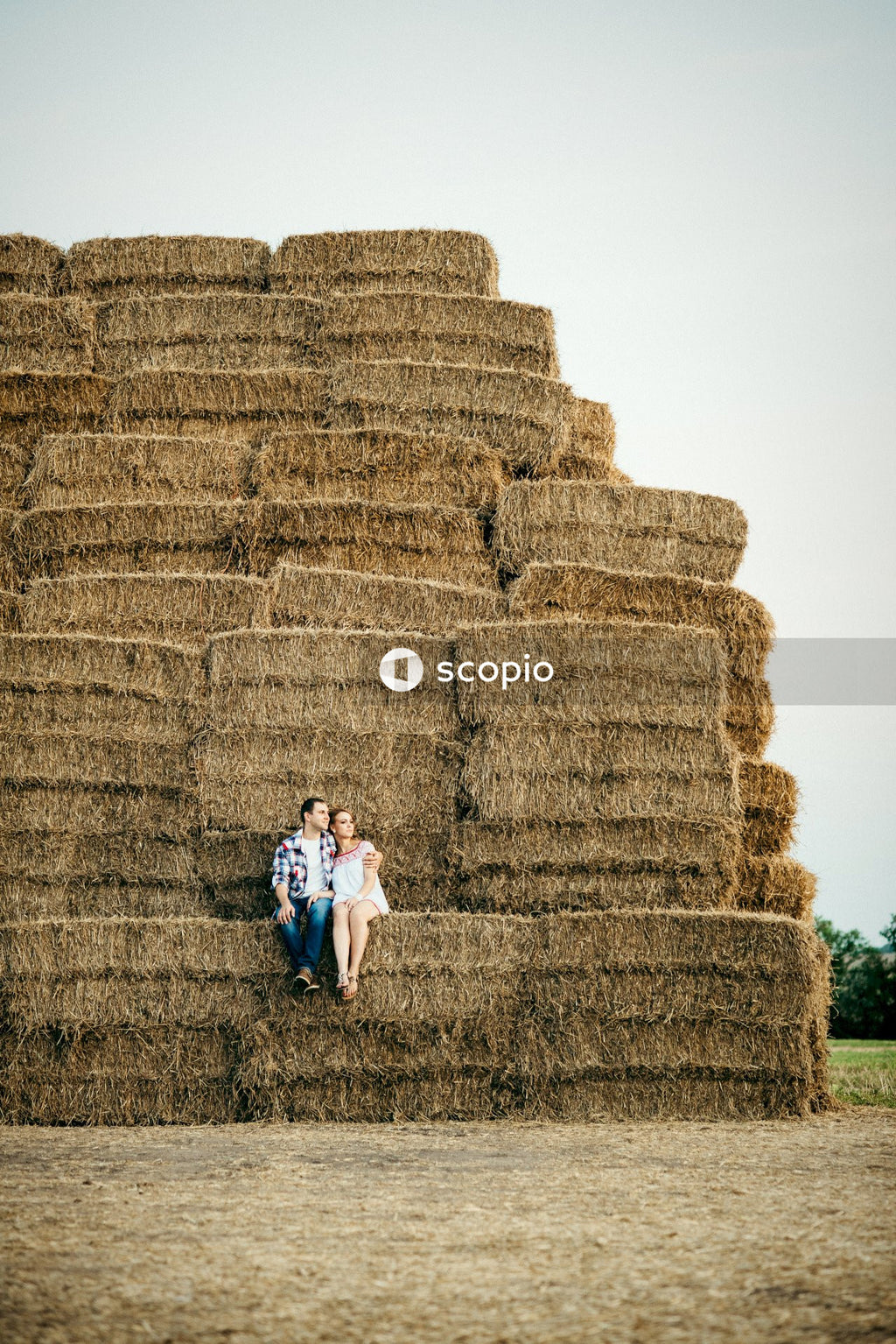 Mature man and woman sitting on packed hay outdoor