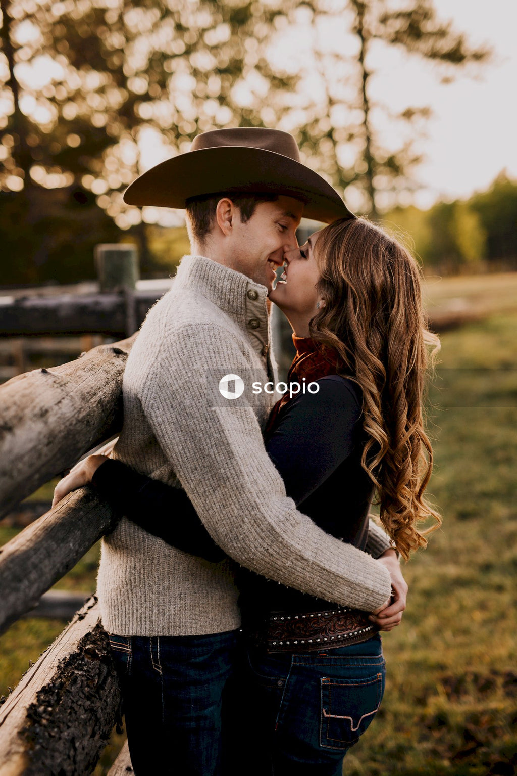 Couple kissing on brown wooden fence