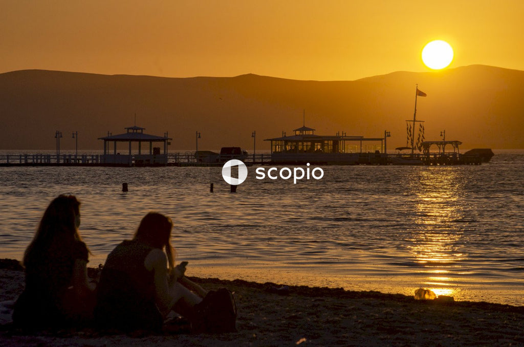 Couple sitting on beach during sunset