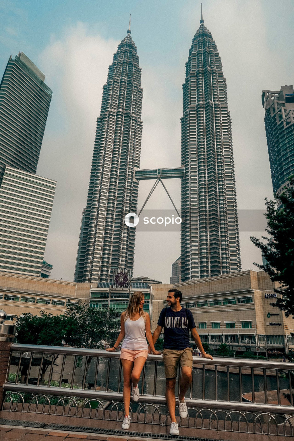 Couple sitting on bench near high rise buildings