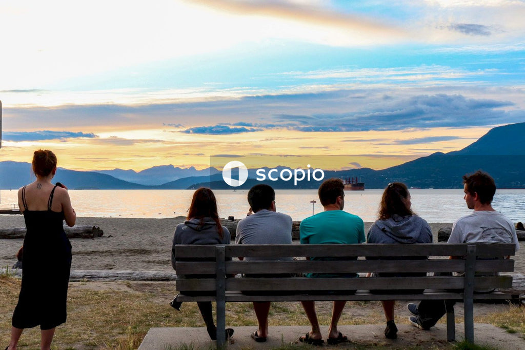 Couple sitting on bench on beach during sunset