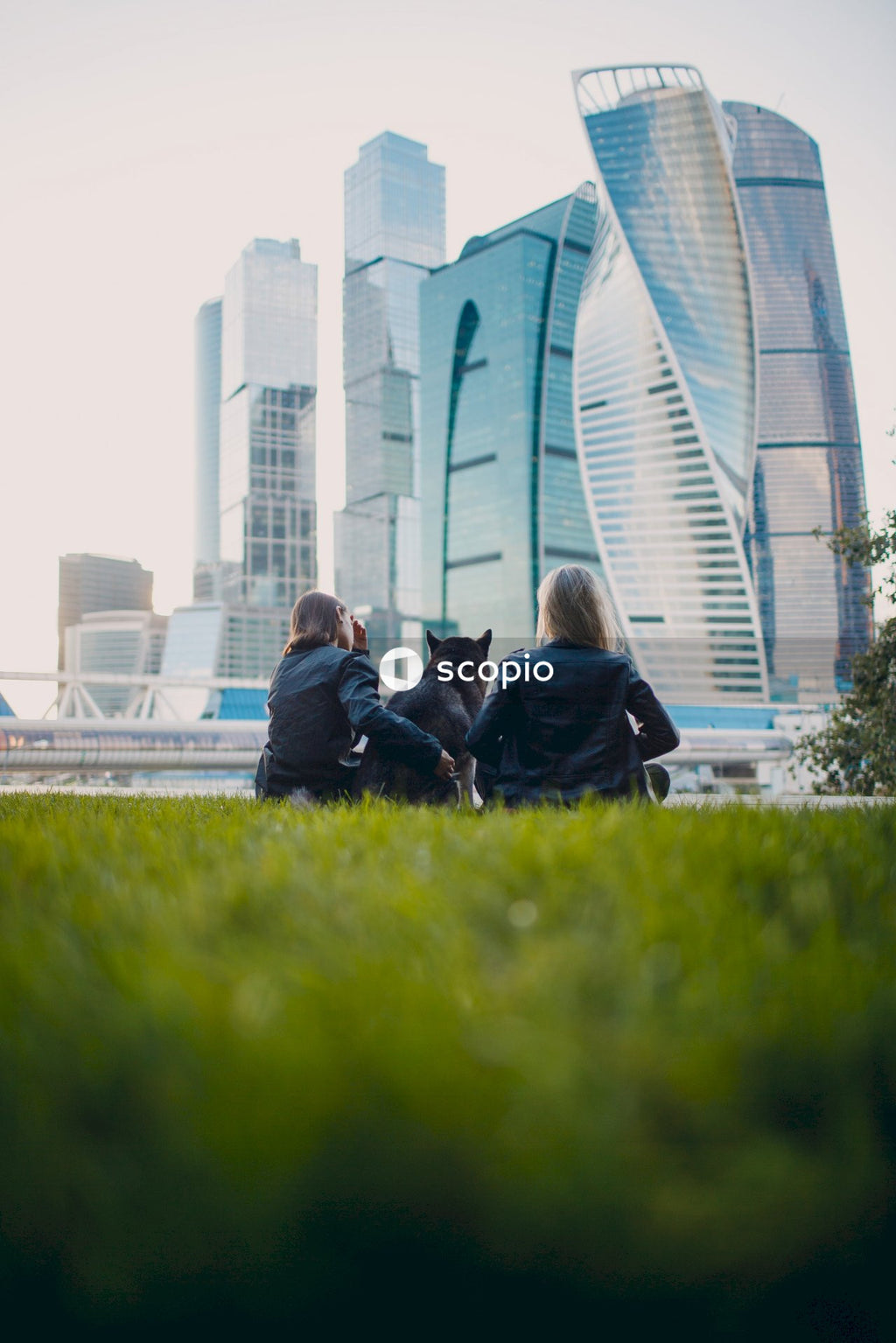 Couple sitting on green grass field near white building