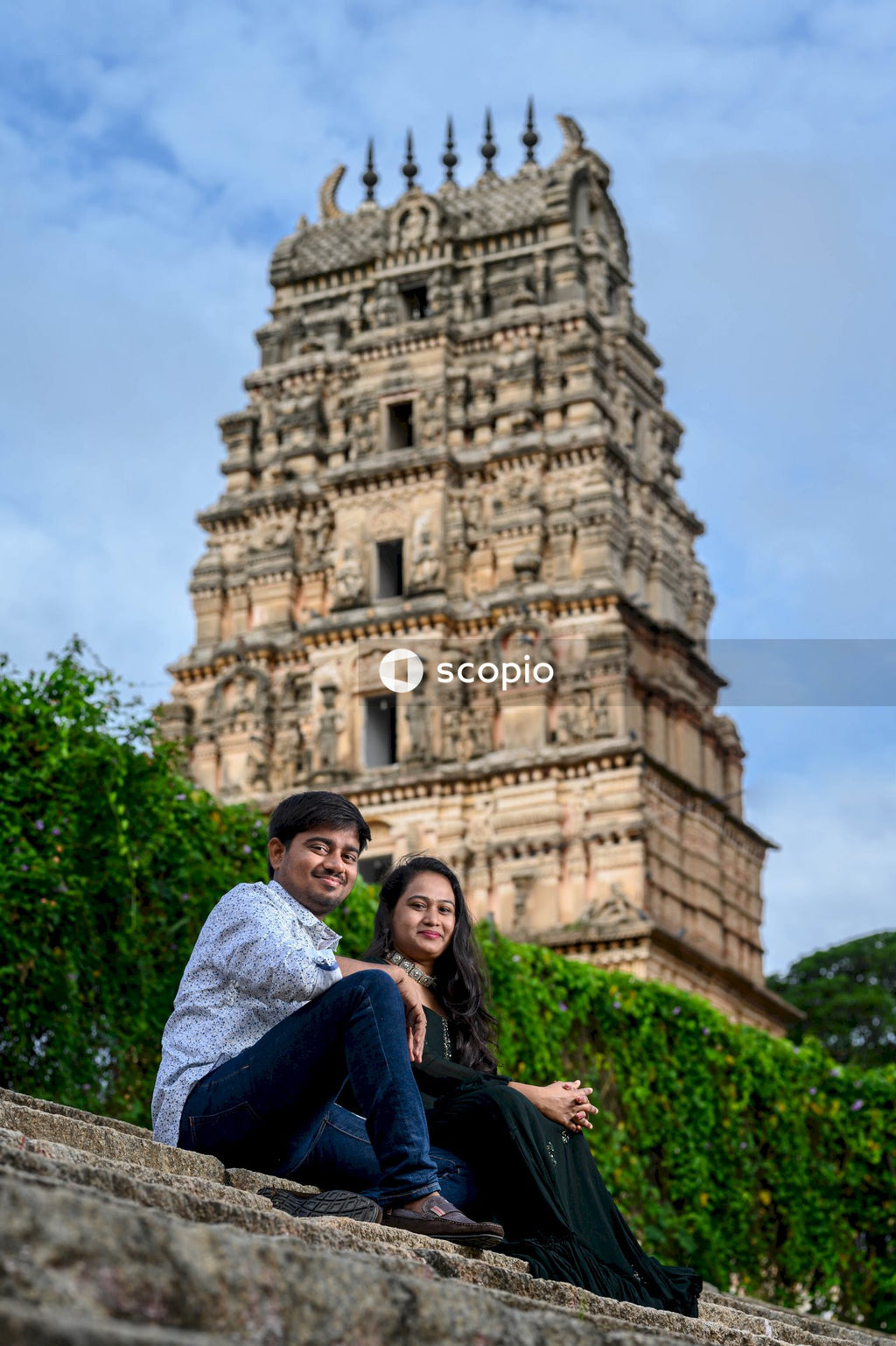 Couple sitting on green grass near brown concrete building