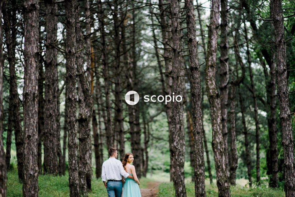 Couple sitting on ground surrounded by trees