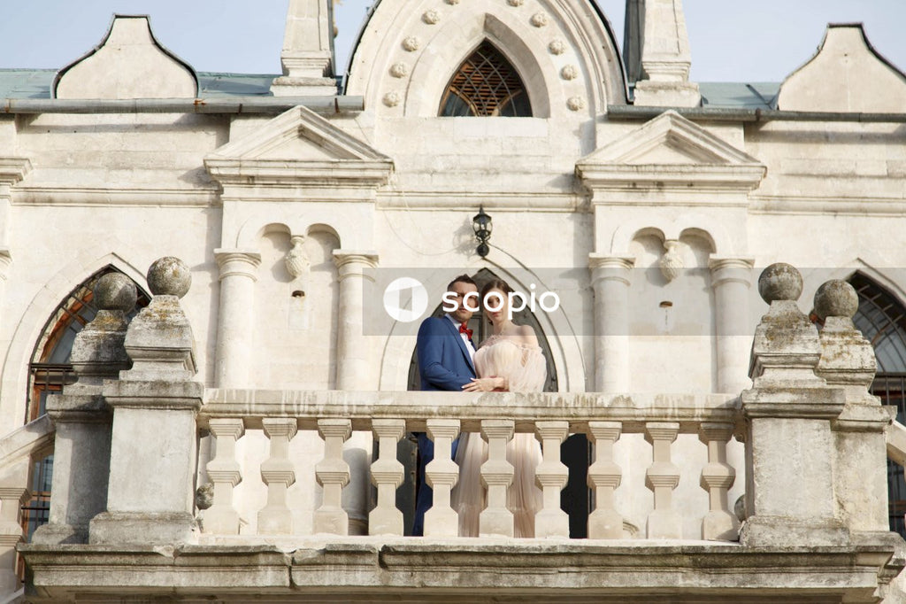 Couple standing in front of white concrete building