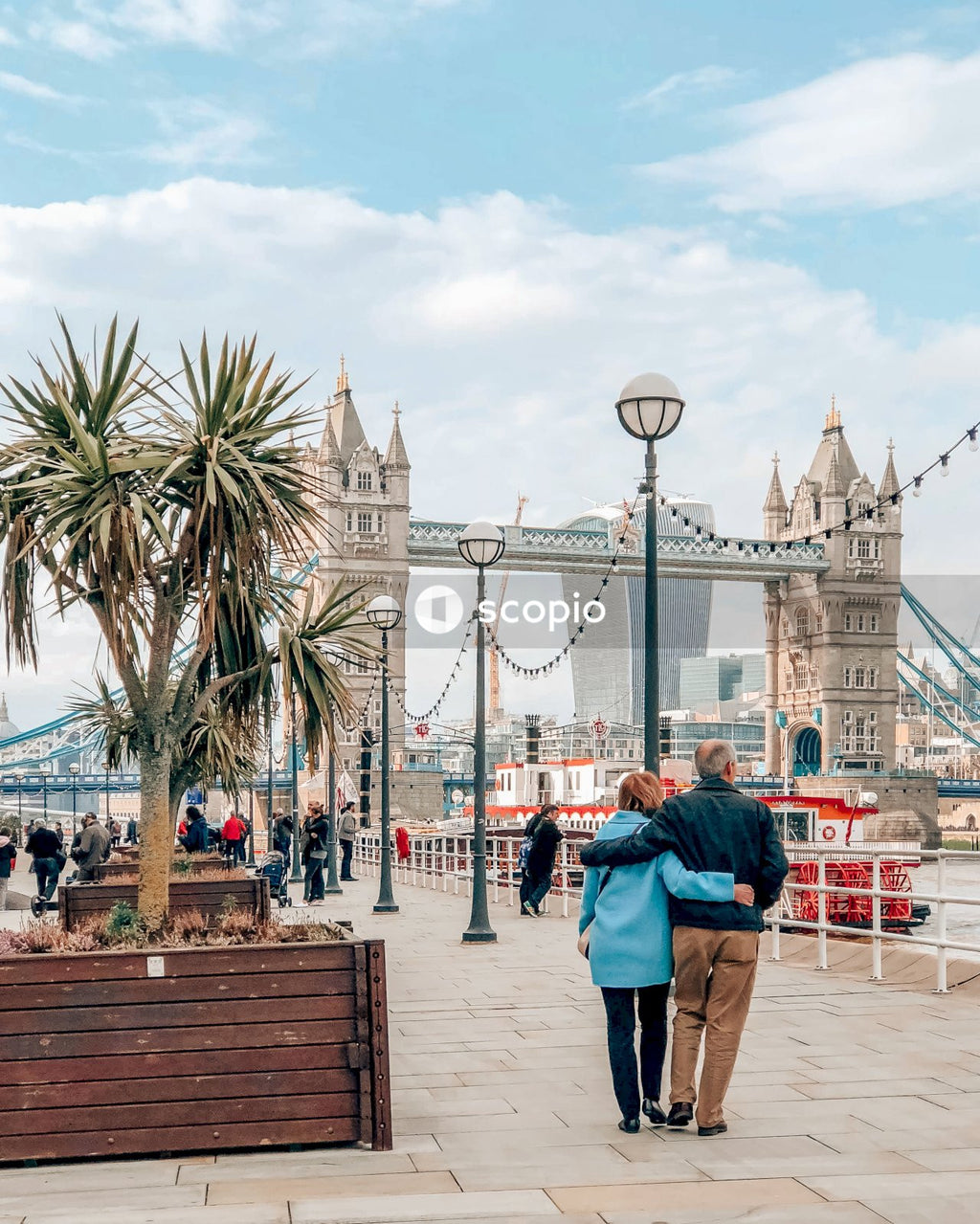 Couple walking on sidewalk near bridge