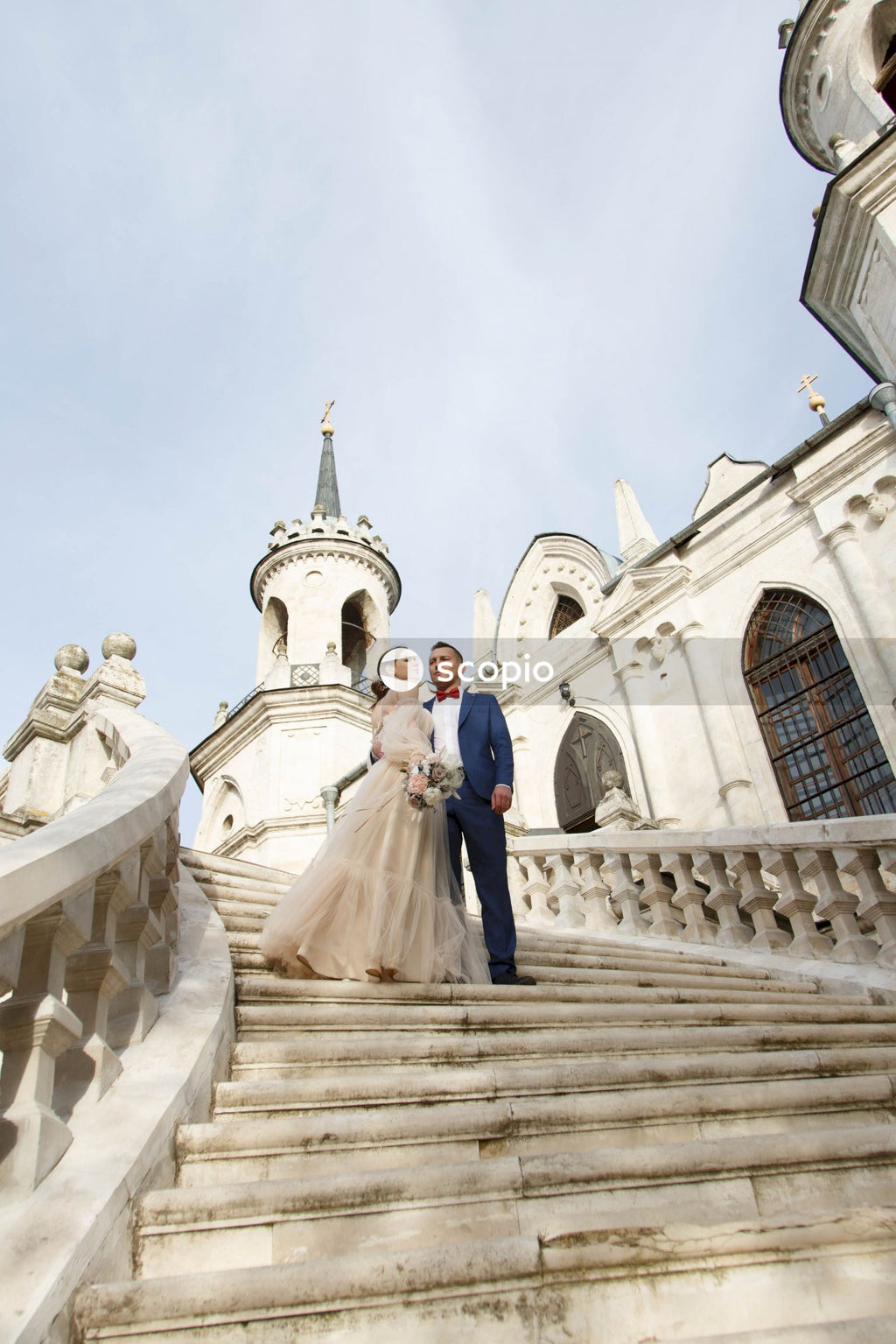 Couple walking on stairs near white concrete building