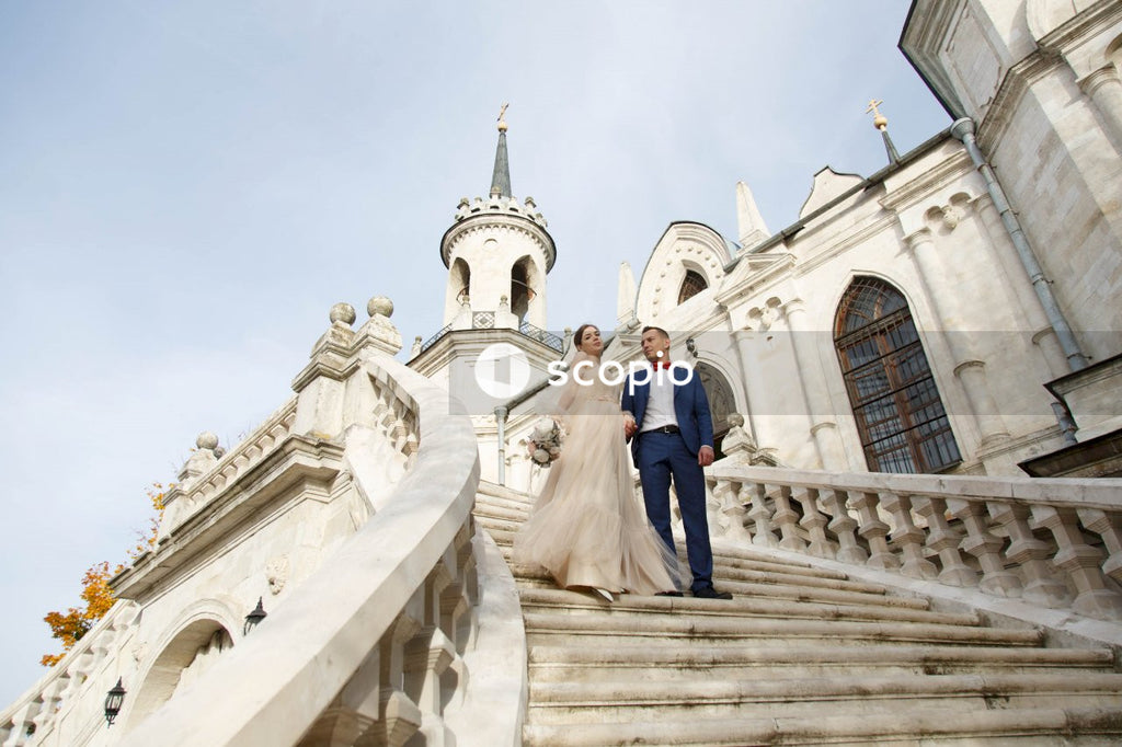 Couple walking on stairs near white concrete building