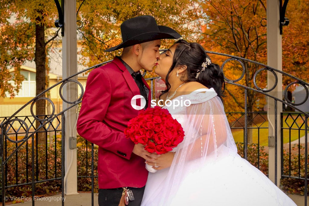 Man in red suit kissing woman in white wedding dress