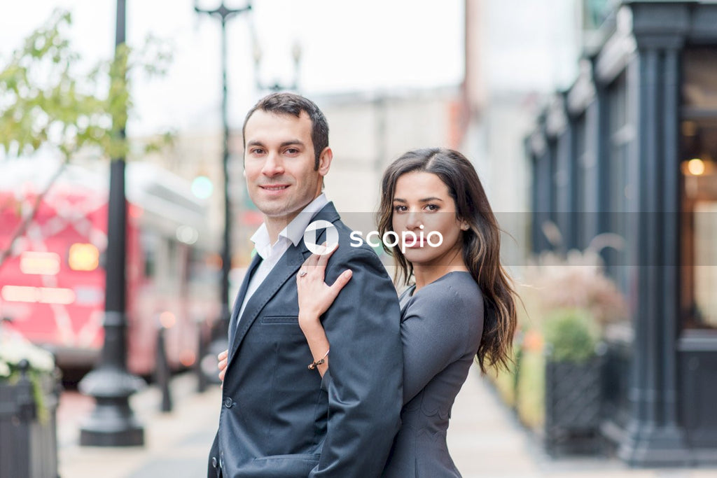 Man in black suit jacket hugging woman in black dress