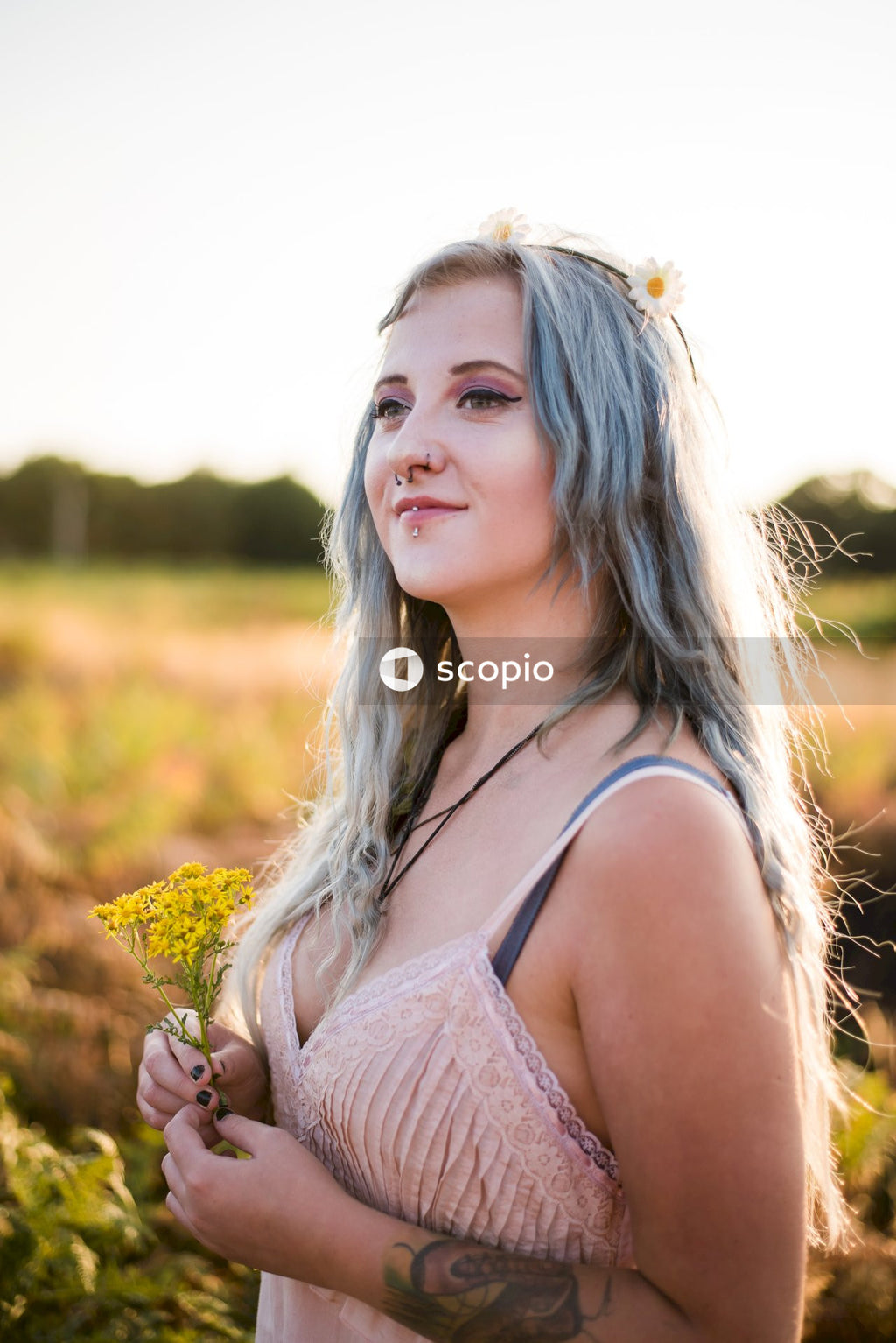 Woman in pink tank top holding yellow flower