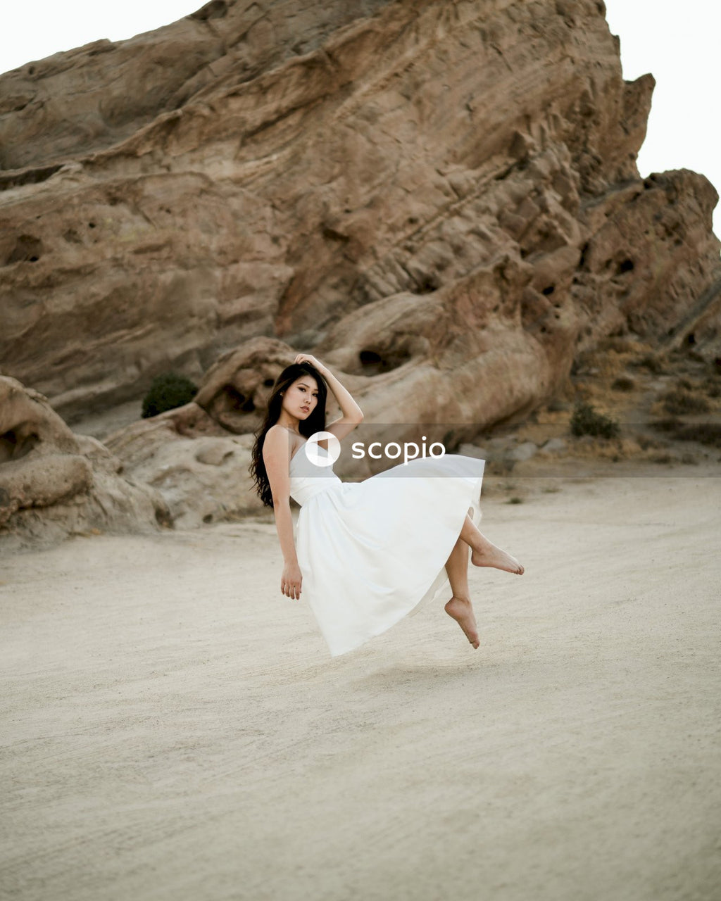 Woman in short light dress standing on sandy shore