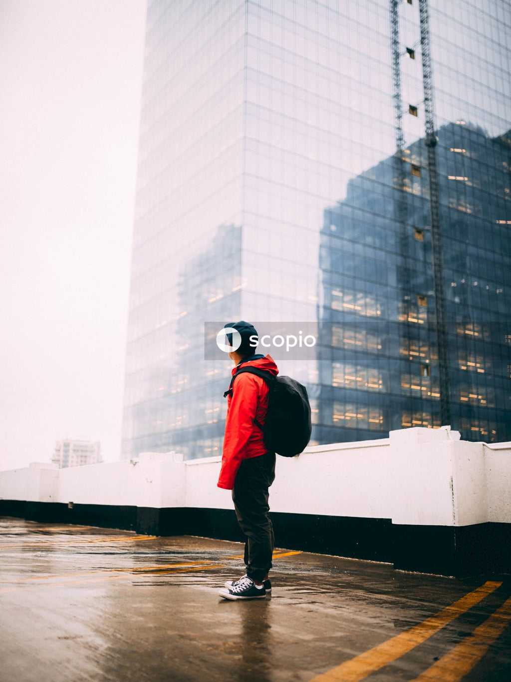 Man in red and black jacket walking on the street
