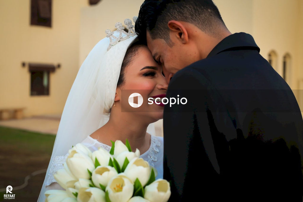 Man and woman smiling while holding white rose bouquet