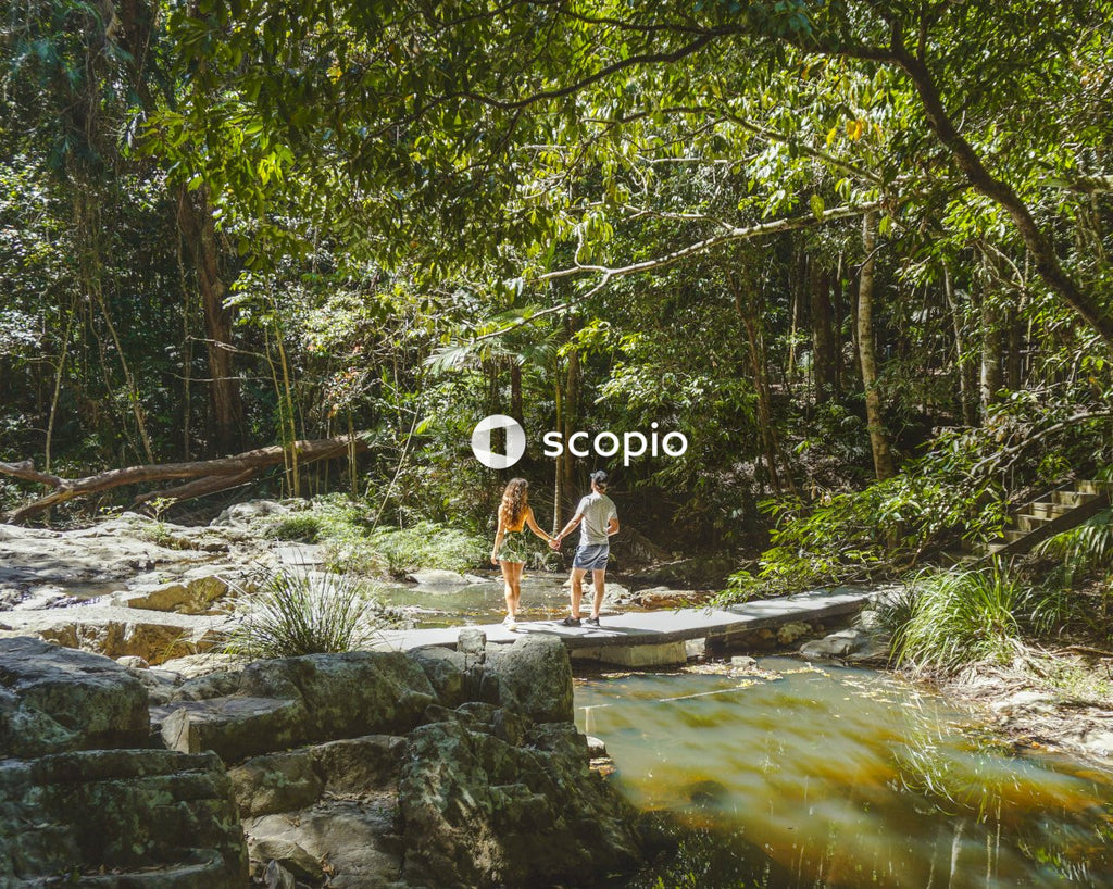 Man and woman standing on bridge above river