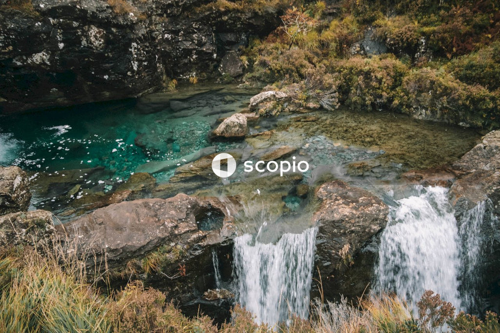 Water falls on brown rocky mountain