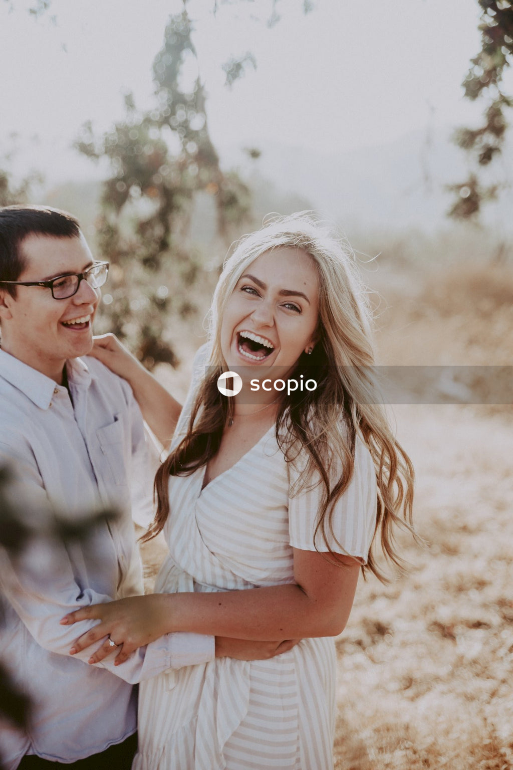 Man and woman smiling and hugging each other outdoor