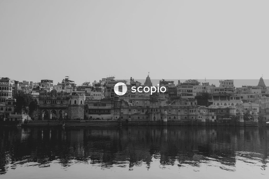 Grayscale photo of city buildings near body of water