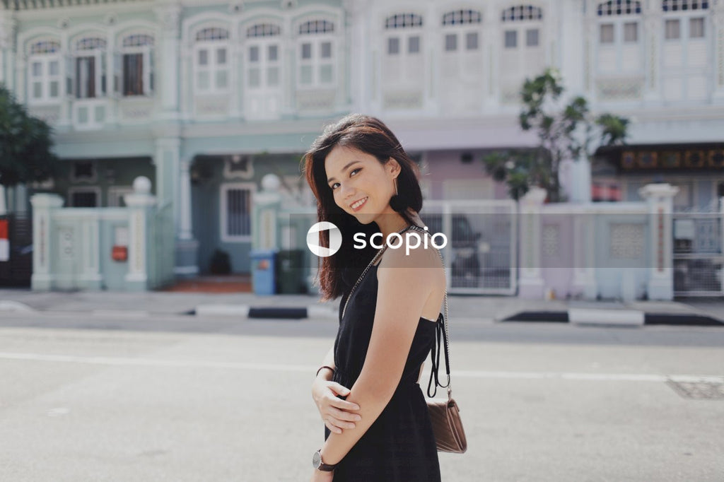 Woman on street posing near building
