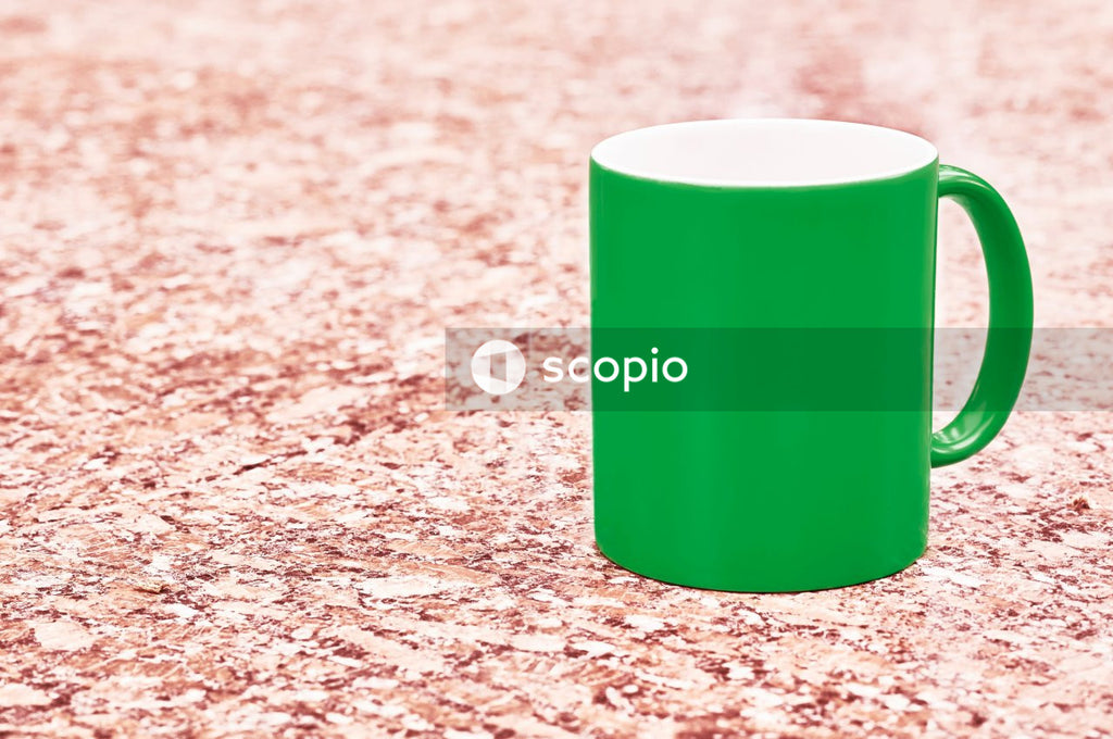 Dark green ceramic cup on a colorful red background