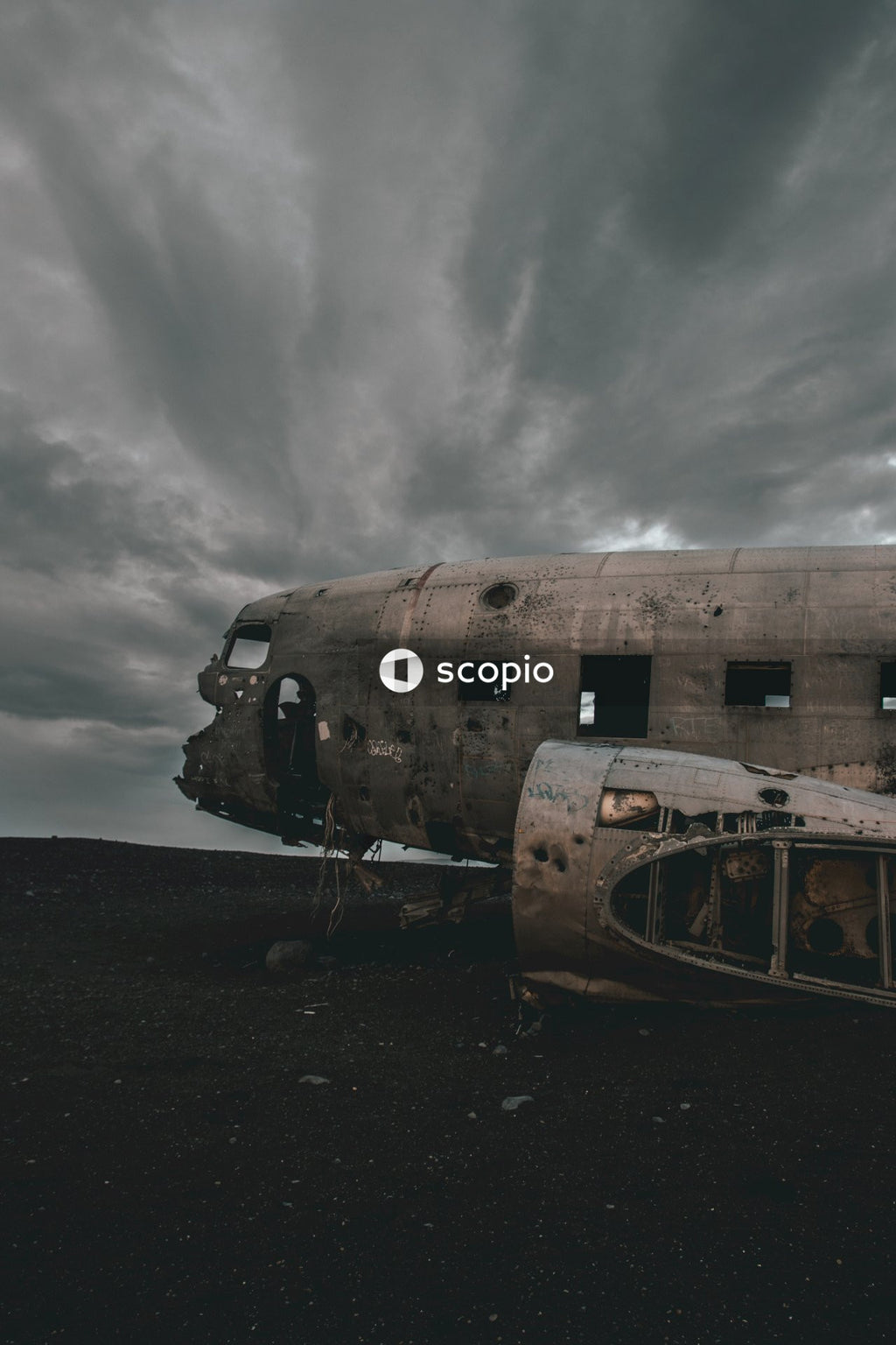 White and brown wrecked ship on brown sand under gray cloudy sky