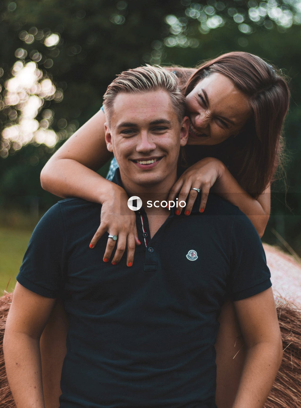 Man in black crew neck t-shirt hugging woman in blue t-shirt