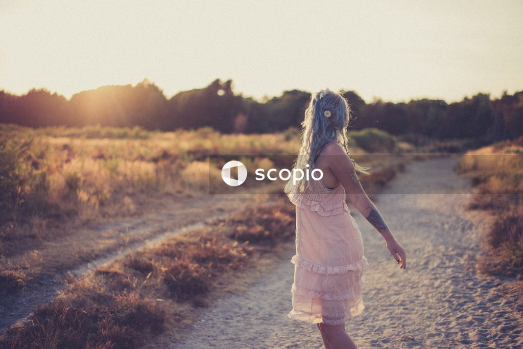 Girl in white dress walking on dirt road