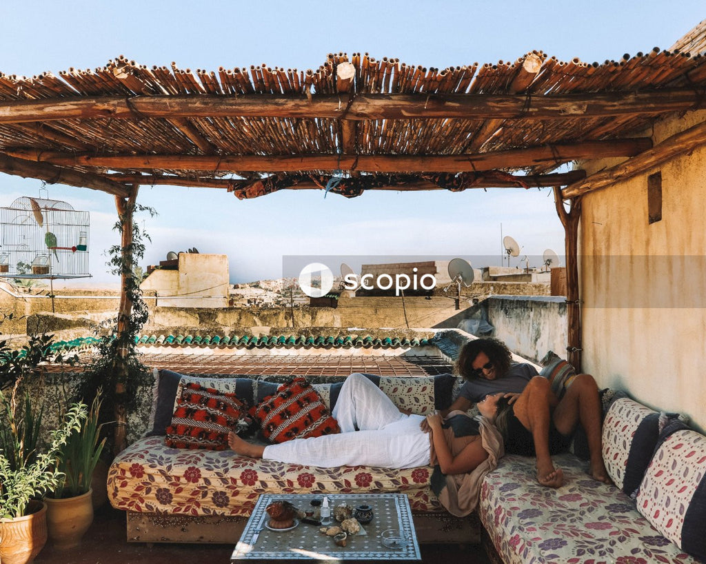 Man and woman lying on sofas outdoor on roof