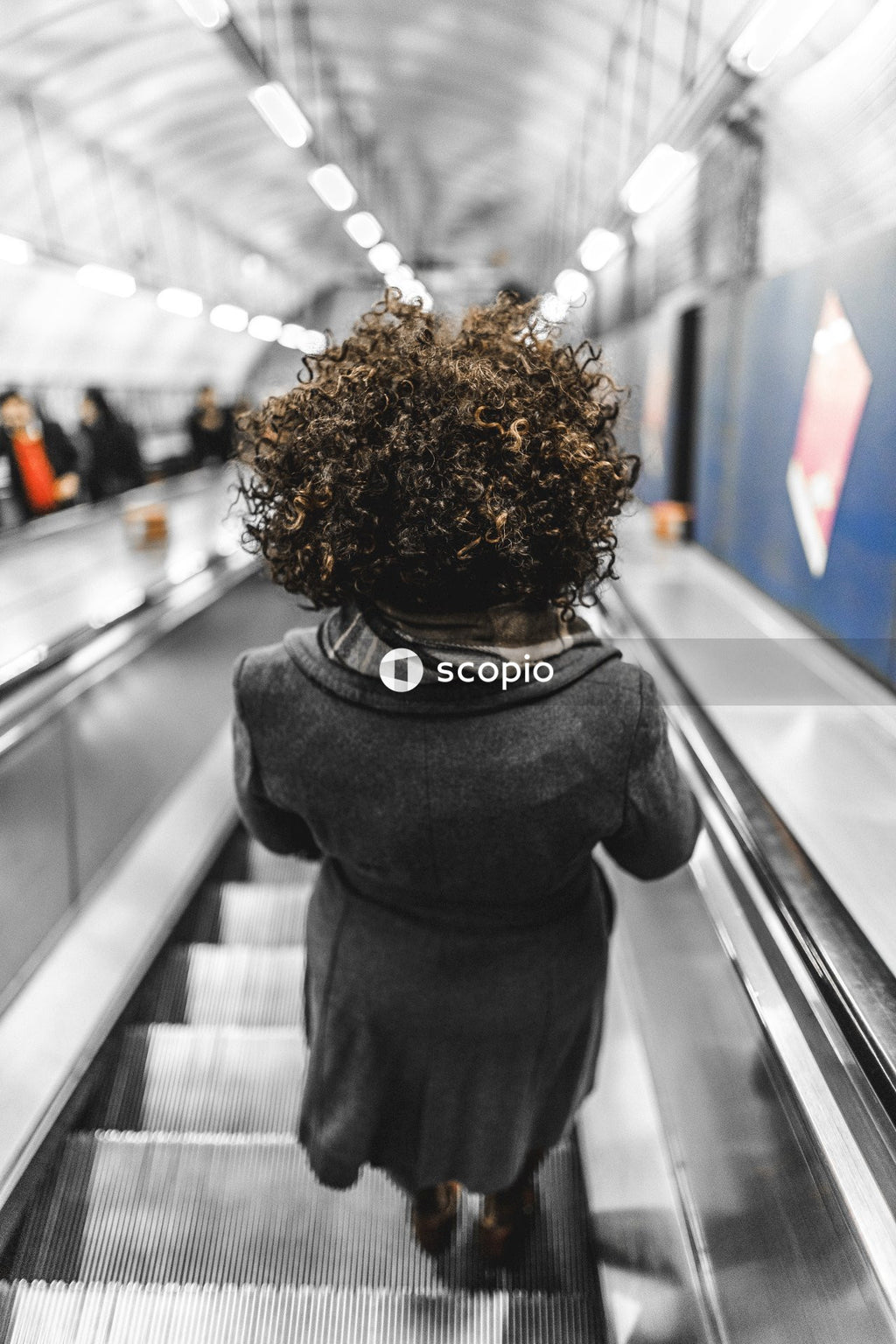 Person in black jacket standing on escalator